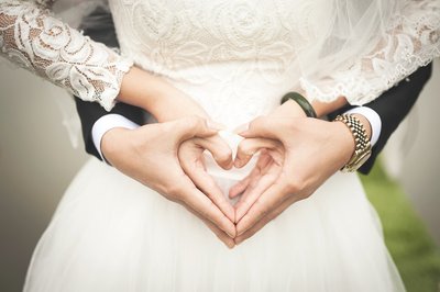 Hochzeitspaar bildet mit Händen ein Herz
